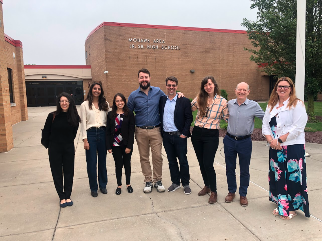 Team members in front of a school building